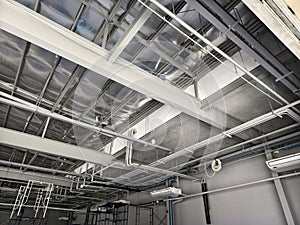 The ceiling of a large building under construction an extensive network of pipes