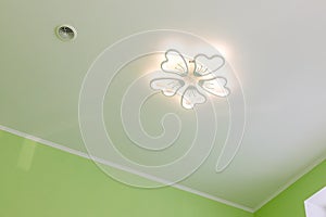 Ceiling with LED chandelier and air vent. Decorative LED chandelier in the form of a flower under the ceiling