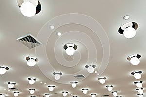 Ceiling mounted cassette type air conditioner and modern lamp light on white ceiling. Duct air conditioner for home, hall or