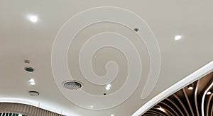 Ceiling mounted cassette type air conditioner and modern lamp light on white ceiling. Duct air conditioner for home, hall or