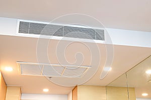 Ceiling mounted cassette type air conditioner and modern lamp light on white ceiling. duct air conditioner for home or office