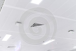 Ceiling mounted cassette type air conditioner and modern lamp light on white ceiling. duct air conditioner for home or office