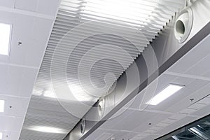 Ceiling mounted cassette type air conditioner and modern lamp light on white ceiling. duct air conditioner for home or office