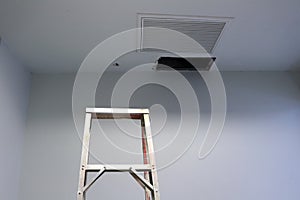 Ceiling panels hole in roof office from drain pipes leakage with step ladder