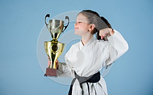 Celebrate achievement. Strong and confident kid. Girl little child in white kimono with belt. Karate fighter child