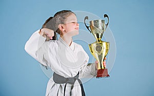 Celebrate achievement. Strong and confident kid. Girl little child in white kimono with belt. Karate fighter child