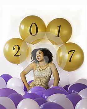 Celebrate good times! Attractive laughing young woman celebrates with balloons.