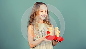 Celebrate love. Kid little girl carefully hold heart soft toy teddy bear. Small girl hold couple in love teddy bear