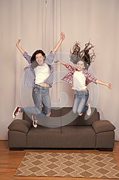 Celebrate womens day. Girls only. Mom and daughter friends. Mother cheerful daughter jumping couch. Happy childhood