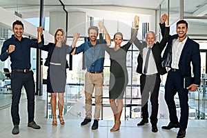 Celebrating another corporate success. Portrait of a confident looking team of coworkers sheering together while photo