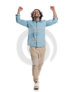 celebrating casual man with hands in the air looking up