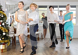 Celebrating Christmas in dance class - girls and boys dance the Moresco dance near New Year tree