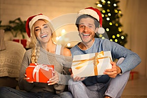 Celebrating Christmas together. Couple holding gift boxes