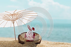 Celebrating Easter holiday on tropical beach. Easter egg on golden sandy beach, blue sea and sky background. copy space