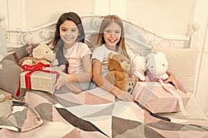 Celebrating the gift of together. Happy small children hold gift boxes. Adorable small girls with presents in bed