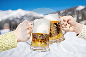 Celebrating with glasses of beer in a ski resort.