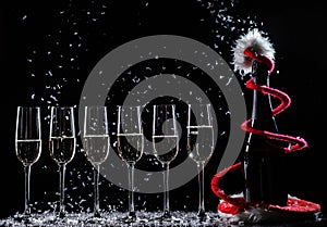 Celebrating new year, birthday, xmas party. Bottle of champagne in a bucket on black backgroud. Santa& x27;s hat