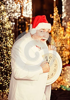 Celebrating New Year. wait for xmas presents. santa man hold alarm clock. new year midnight. clock showing almost