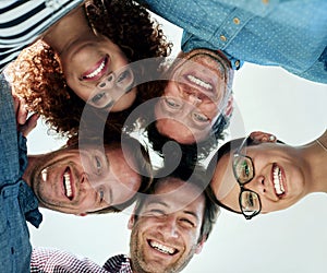 Celebrating our success. Low angle portrait of a group of smiling coworkers in a huddle.