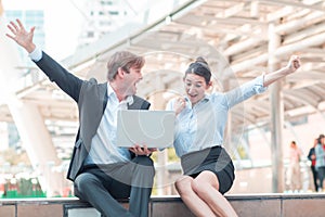 Celebrating success.Excited cheerful young business couple keeping arms raised and expressing positivity as they know the succes