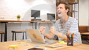 Celebrating Success, Excited and Joyous Man Working in Office on Laptop