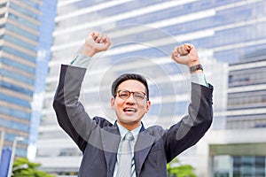 Celebrating success. happy businessman  while standing outdoors with office building in the background