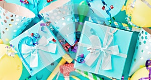 Celebration background with gift box colorful party streamers, confetti and birthday party hats top view