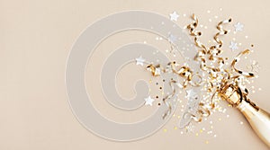 Celebration background with golden champagne bottle, confetti stars and party streamers. Christmas, birthday or wedding. Flat lay photo
