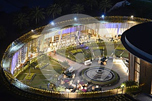 Celebration, function site is beautifully illuminated with strings of golden lights. fountain, landscape Night time.