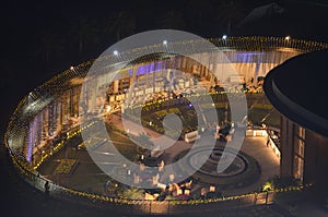 Celebration, function site is beautifully illuminated with strings of golden lights. fountain, landscape Night time.