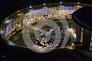 Celebration, function site is beautifully illuminated with strings of golden lights. fountain, landscape Night time.