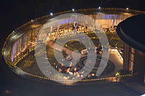 Celebration, function site is beautifully illuminated with strings of golden lights. fountain, landscape Night time.