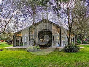 A celebration hall surraunded by tall trees in the afternoon light