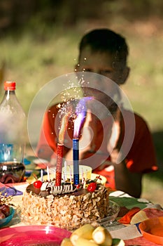 Celebration, holiday birthday cake with candles and fireworks light on a black background