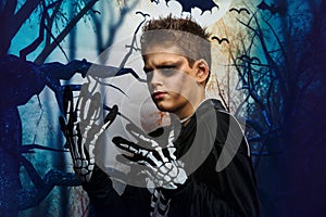 Celebration of holiday Halloween, the cute 8 year boy  in the image, costume, the skeleton theme, the vampire, bat concept