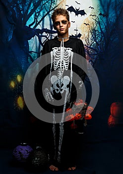 Celebration of holiday Halloween, the cute 8 year boy  in the image, costume, the skeleton theme, the vampire, bat concept