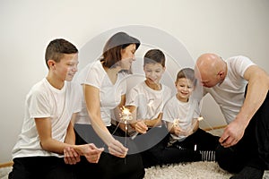 celebration, holidays and christmas concept - happy family with sparklers having fun at dinner party at home