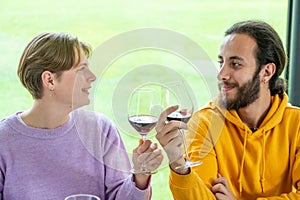 celebration, holidays and people concept - happy biracial couple drinking red wine at restaurant