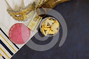 Celebration of Jewish Purim holiday with hamantaschen, Hamans ears cookies, carnival mask, a noisemakers photo