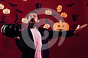 Celebration party. Halloween man with bloody beard hold pumpkin. Scary man with horror face, facial expression.