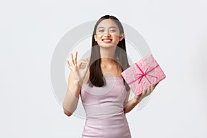 Celebration, party and holidays concept. Pleased and satisfied beautiful asian girl celebrating birthday, receive gift