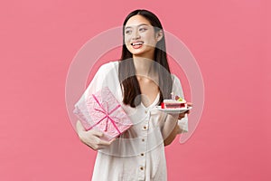 Celebration, party holidays and fun concept. Dreamy happy pretty birthday girl in white dress, smiling and looking away