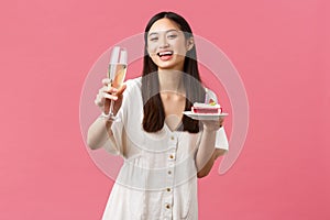 Celebration, party holidays and fun concept. Happy asian woman celebrating birthday enjoying tasty b-day cake and