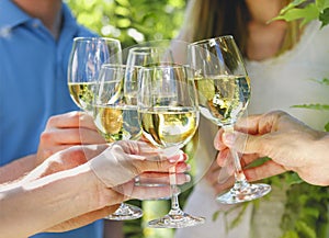 Celebration. People holding glasses of white wine making a toast