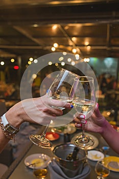 Celebration. People holding glasses of white wine making a toast.