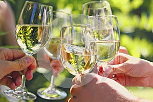 Celebration. People holding glasses of white wine making a toast