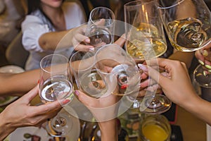 Celebration. People holding glasses of white wine making a toast.