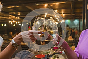 Celebration. People holding glasses of white wine making a toast.