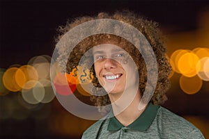 Celebration, people and holidays concept - happy curly guy having a Christmas or New Year party on the background of festive