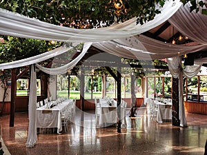 Celebration venue decorated with white drapes and green vines